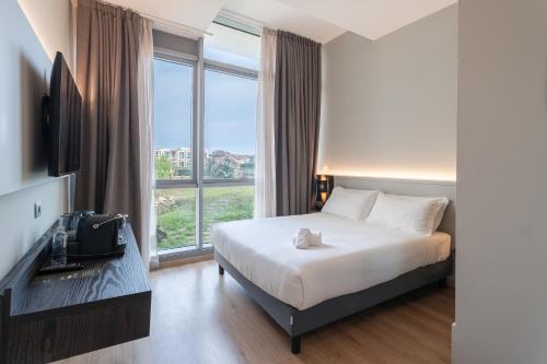 a hotel room with a bed and a large window at Smy Pisa Plaza in Pisa