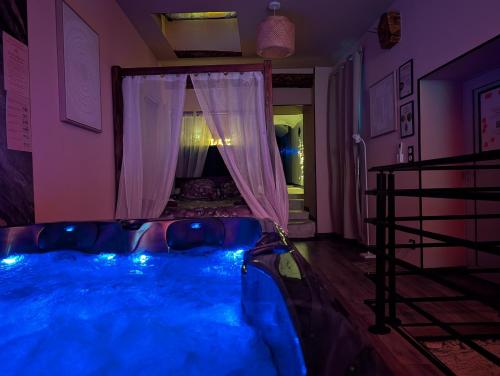 a room with a tub with blue lights in it at Loveroom Romantique avec Spa et Secret Room - A proximité des Lacs - La Mure in La Mure