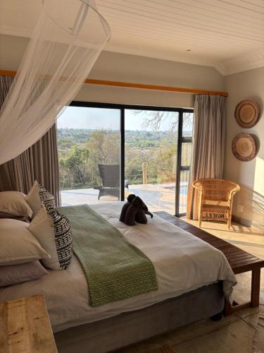 a teddy bear sitting on a bed in a bedroom at MANZINI RIVER HOUSE - Mjejane Private Game Reserve, Greater Kruger National Park in Hectorspruit
