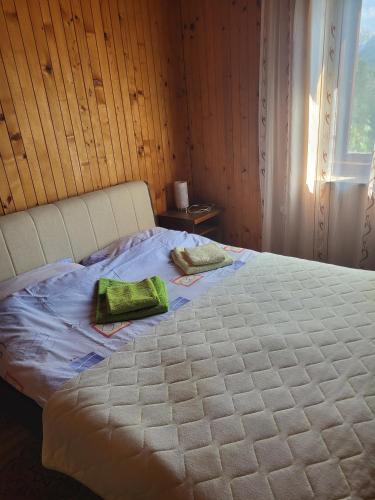 a white bed with two green towels on it at Kod Marijanovića in Andrijevica