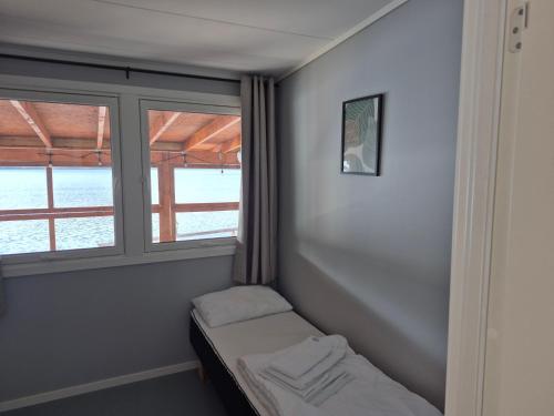 a small room with a bed and a window at Egenes Camping in Flekkefjord
