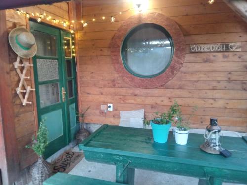 a wooden wall with a green table and a mirror at Kuća za odmor Urša in Brod na Kupi