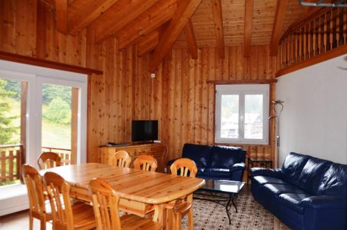 a living room with a wooden table and a couch at Immeuble La Foret in Vex