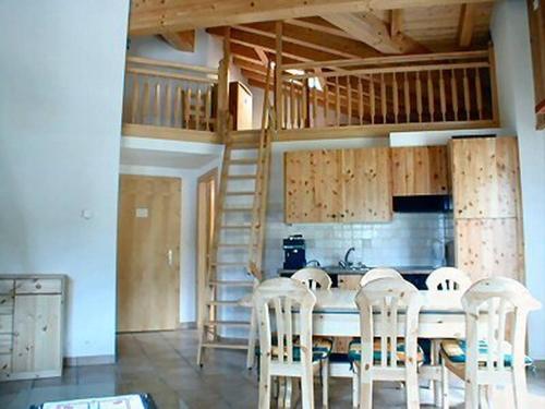 a kitchen with a table with chairs and a staircase at Immeuble La Foret in Vex