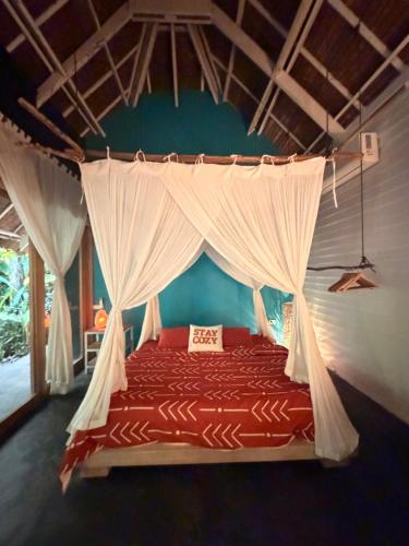 a bedroom with a bed with a mosquito net at Tropical Jungle Villa 5 min walk to Cloud 9 in General Luna