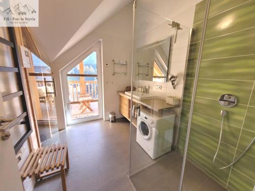 a bathroom with a shower and a washing machine at Mountain Suite A10 - by FiS in Tauplitz