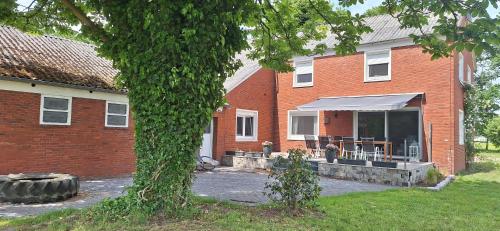 a brick house with a large window with a patio at Ferienhaus Dat Landhuus 95158 in Rhauderfehn