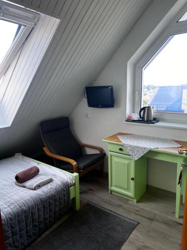 a bedroom with a desk and a bed and a chair at Szyper 2 in Jastarnia