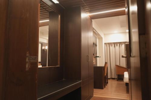 a bathroom with a mirror and a door to a room at Hotel Rajhans Regent in Bhopal