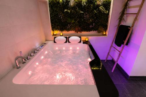 a bathroom with a tub with two toilets in it at Beau gîte avec jacuzzi in Barr