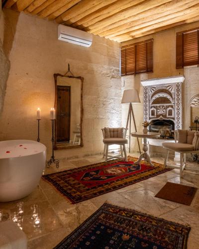 a living room with a tub and a fireplace at Petra Inn Cappadocia Luxury in Uçhisar