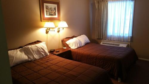 a hotel room with two beds and a window at Coach Stop Motel in Wellsboro
