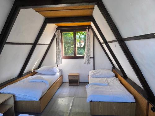 two beds in a room with a window at Kemp Prachovská osma in Libuň