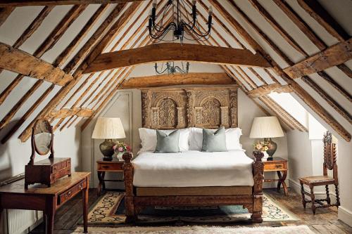 a bedroom with a large bed with a wooden headboard at Chilston Park Hotel in Maidstone