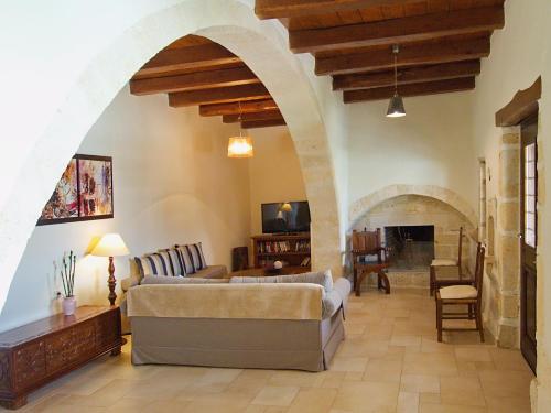 a living room with two couches and a fireplace at Villa Argiro Plaka Crete in Plaka