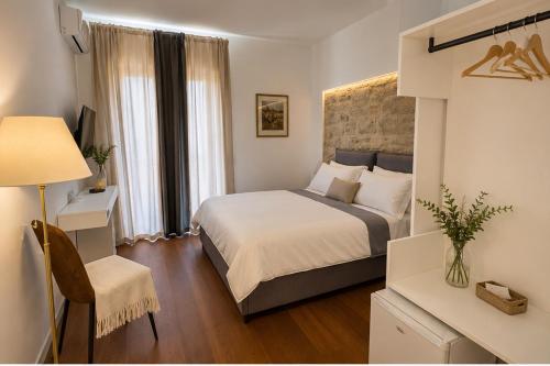 a bedroom with a bed and a desk and a chair at Locanda di Ody in Pietra Montecorvino