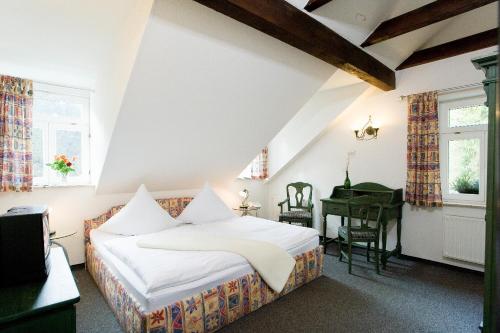 a bedroom with a bed and a desk and a piano at Hotel Forsthaus in Bad Schandau