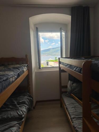 a room with two bunk beds and a window at Sanrise Hostel in Baošići