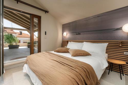 a bedroom with a large bed and a large window at Fančita Rooms B&B in Vrsar