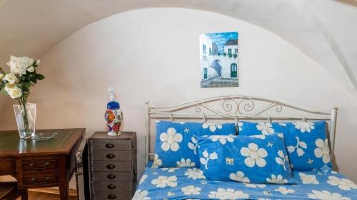 a bedroom with a bed with blue and white pillows at Il Salento di Socrate e Socrata in Ugento