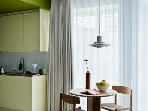 a kitchen with a table with a bowl of fruit on it at Folk Copenhagen in Copenhagen