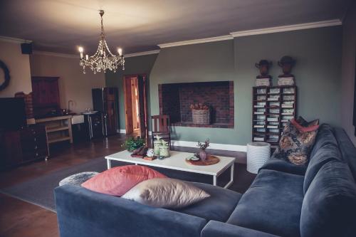 a living room with a blue couch and a table at Station House Simondium in Simondium