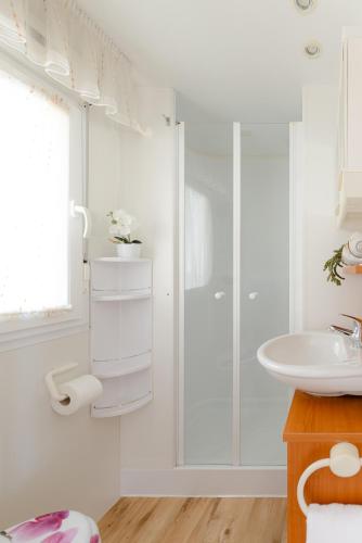 a white bathroom with a shower and a sink at Bol Cutie in Murvica