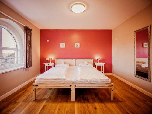 a bedroom with a large bed with red walls at Wombat's City Hostel London in London
