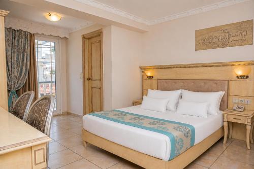 a bedroom with a bed and a desk and a window at Parthenon Art Hotel-Seaside Collection in Olympic Beach