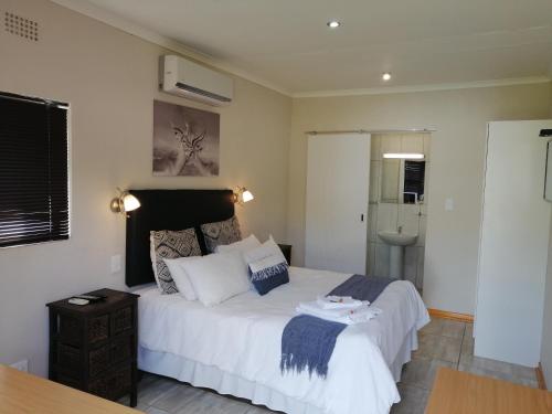 a bedroom with a large white bed and a sink at Twilight Inn in Vryheid