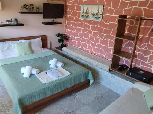 a room with two beds with towels on them at The cave of Cyclops in Makri