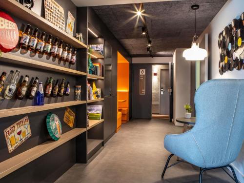 a room with a blue chair and shelves at ibis Compiegne in Compiègne