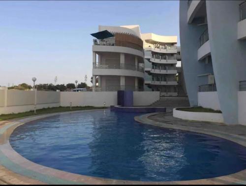 a large swimming pool in front of a building at Ninou diamants in Harqalah