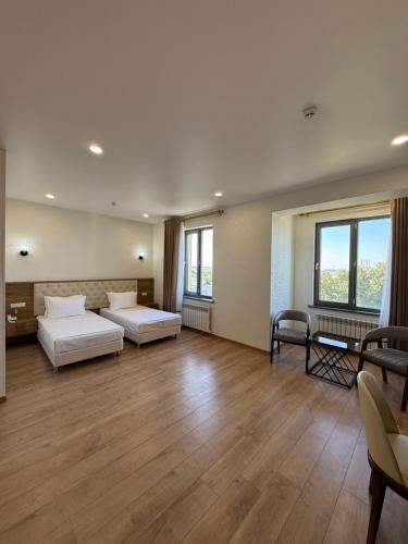 a large room with two beds and a couch at Safia Plaza Hotel in Bukhara