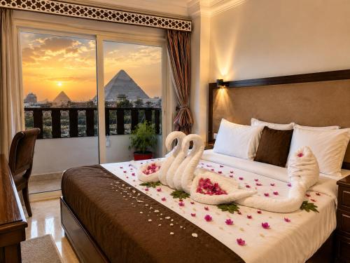 two swans in towels sitting on a bed in a hotel room at Flower Pyramids Inn in Cairo