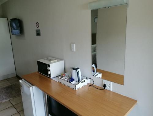 a kitchen counter with a toaster and a microwave at Twilight Inn in Vryheid