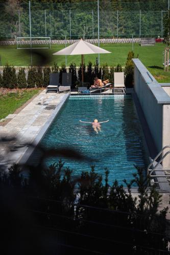 a person swimming in a swimming pool at Revier Boutique Hotel Kaprun in Kaprun