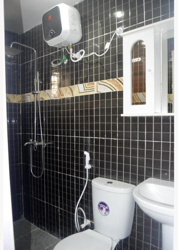 a bathroom with a shower and a toilet and a sink at Wavelength Hotel and uites in Ibadan