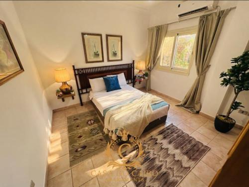 a bedroom with a bed with blue pillows at Casa Do Cairo-Sharm Alsheikh in Sharm El Sheikh