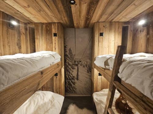 two bunk beds in a room with wooden walls at Immeuble Les Mélèzes in Les Collons