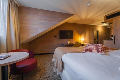 a hotel room with two beds and a tv at Van der Valk Hotel Emmen in Nieuw-Amsterdam