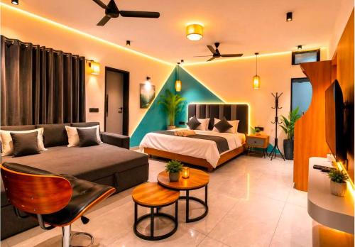 a living room with a bed and a couch at The Peach Boho in Mount Ābu