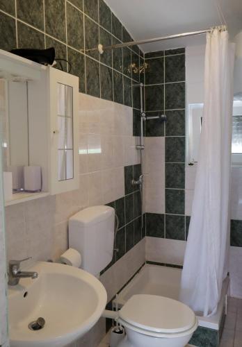 a bathroom with a white toilet and a sink at Apartments Verica in Pag