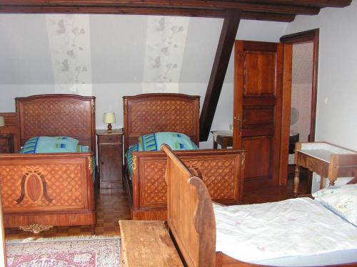 a bedroom with three beds and wooden furniture at Le Sonnenglanz in Beblenheim