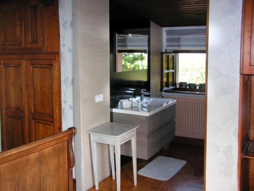 a bathroom with a sink and a stool in it at Le Sonnenglanz in Beblenheim