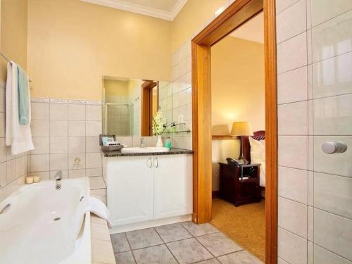 a bathroom with a tub and a sink and a mirror at Centurion Golf Suites Boca Walk in Centurion