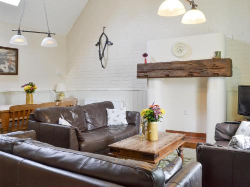 a living room with leather furniture and a table at Riverview - Ioj in Brandesburton
