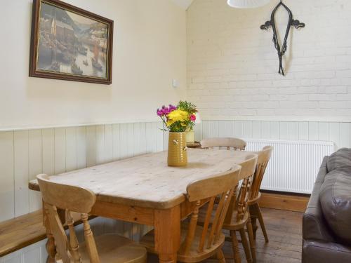 a dining room table with chairs and a vase of flowers at Riverview - Ioj in Brandesburton