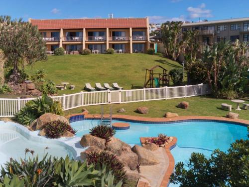 a resort with a swimming pool and a building at Secret Sands Glenmore Beach in Port Edward