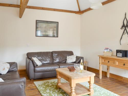 a living room with a leather couch and a table at Broad Leaf - Iok in Brandesburton